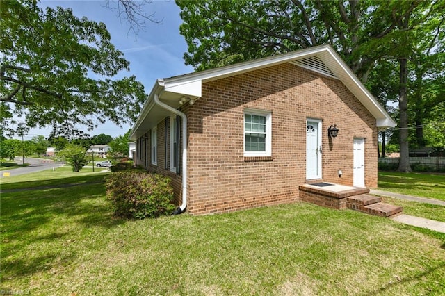 view of front of house featuring a front lawn and brick siding