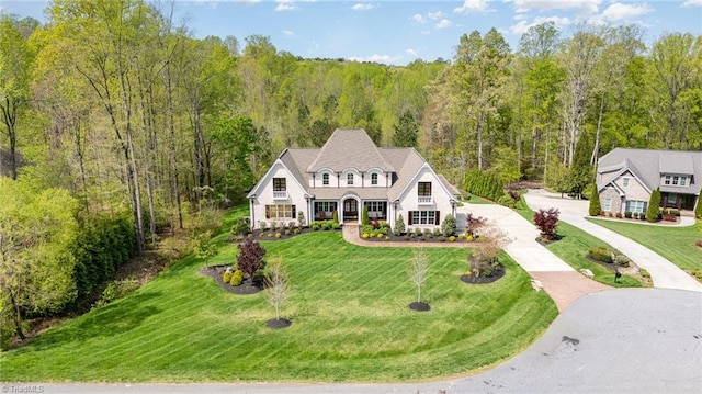 6323 Nesting Way, Oak Ridge, NC 27310 - view of front of house featuring concrete driveway, a wooded view, and a front yard