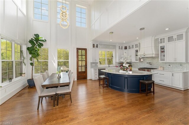 6323 Nesting Way, Oak Ridge, NC 27310 - kitchen featuring a kitchen breakfast bar, light countertops, wood finished floors, a kitchen island, and white cabinetry