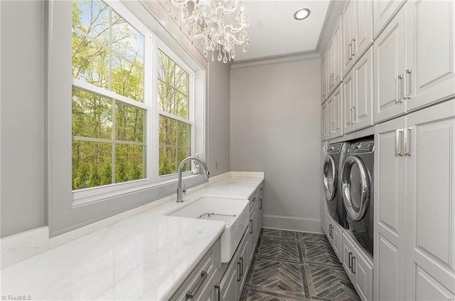6323 Nesting Way, Oak Ridge, NC 27310 - laundry area featuring a sink, cabinet space, washing machine and dryer, baseboards, and a notable chandelier