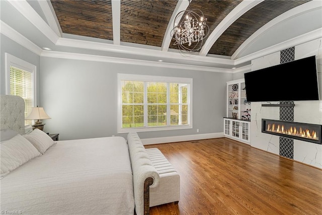 6323 Nesting Way, Oak Ridge, NC 27310 - bedroom featuring wood finished floors, crown molding, baseboards, a fireplace, and a notable chandelier