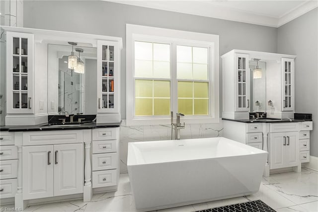 6323 Nesting Way, Oak Ridge, NC 27310 - bathroom featuring two vanities, a sink, a freestanding tub, marble finish floor, and ornamental molding