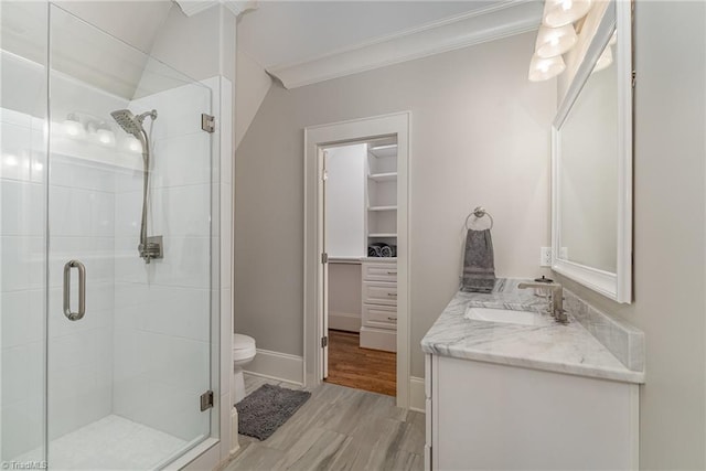 6323 Nesting Way, Oak Ridge, NC 27310 - bathroom featuring a walk in closet, a shower stall, vanity, and ornamental molding