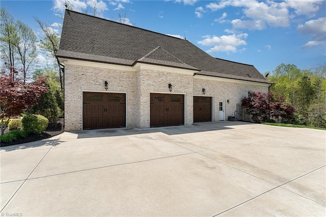 6323 Nesting Way, Oak Ridge, NC 27310 - view of home's exterior featuring a garage, brick siding, roof with shingles, and concrete driveway
