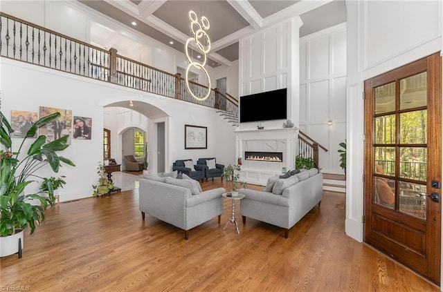 6323 Nesting Way, Oak Ridge, NC 27310 - living area featuring light wood-type flooring, a high ceiling, arched walkways, and stairs