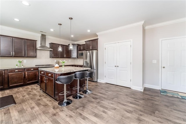 2110 Owls View Ln, Colfax, NC 27235 - kitchen with wall chimney range hood, stainless steel appliances, dark brown cabinetry, light wood finished floors, and ornamental molding