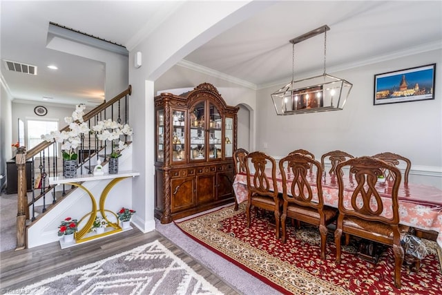 2110 Owls View Ln, Colfax, NC 27235 - dining area featuring a chandelier, stairs, wood finished floors, crown molding, and arched walkways