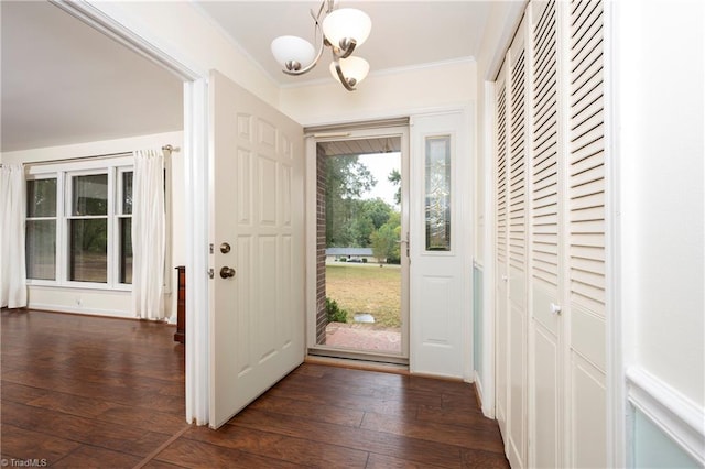 entryway featuring crown molding, dark hardwood / wood-style flooring, and a notable chandelier