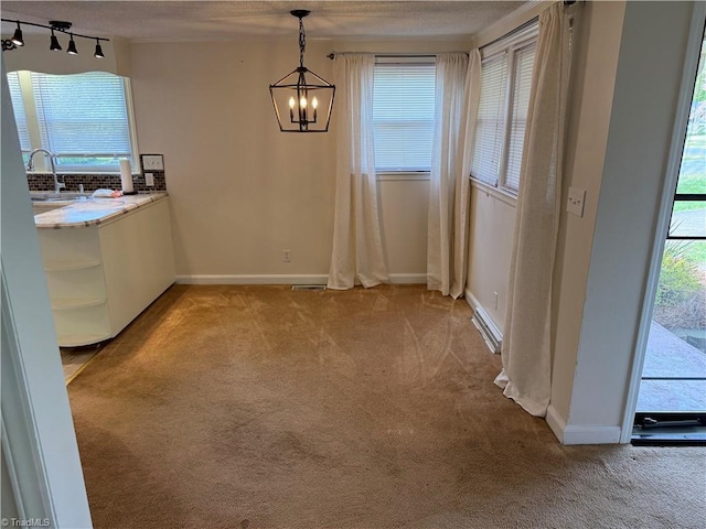 1632 Sanford Dr, Winston-Salem, NC 27105 - unfurnished dining area featuring a sink, plenty of natural light, a notable chandelier, and light carpet