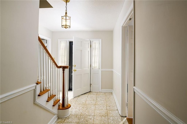 foyer featuring stairway and baseboards