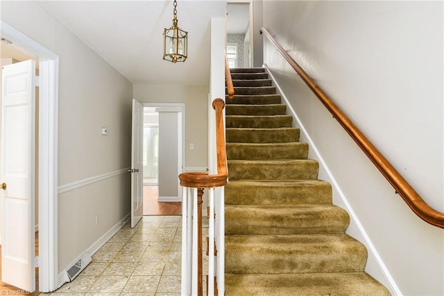 stairs with baseboards, visible vents, and tile patterned flooring