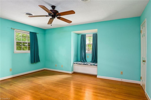 spare room with baseboards, visible vents, ceiling fan, and light wood-style floors