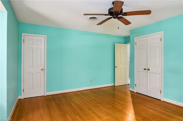 unfurnished bedroom featuring visible vents, ceiling fan, a closet, baseboards, and light wood finished floors