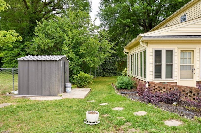 view of yard with an outdoor structure, a storage unit, and fence