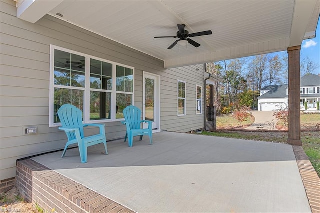 view of patio / terrace featuring a garage and ceiling fan