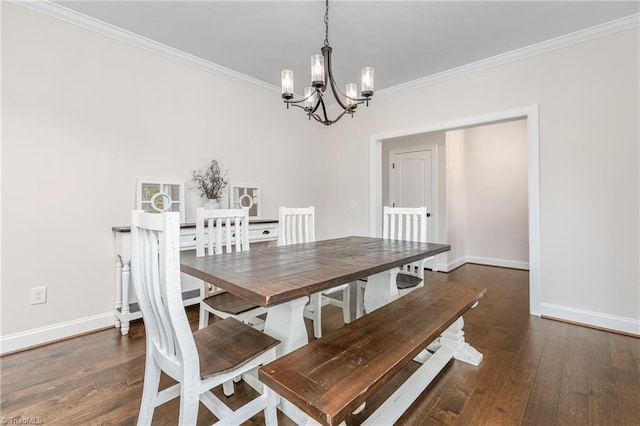 dining space with dark wood-type flooring, crown molding, and a chandelier