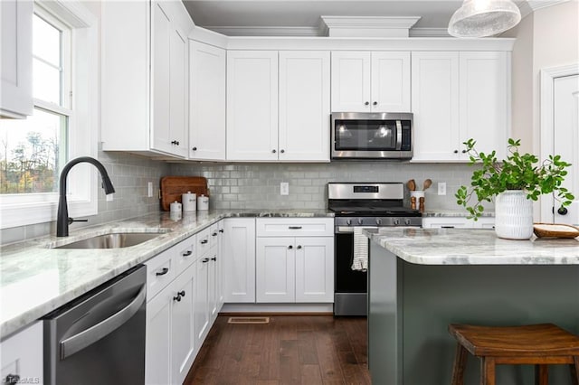 kitchen featuring appliances with stainless steel finishes, sink, crown molding, and white cabinets