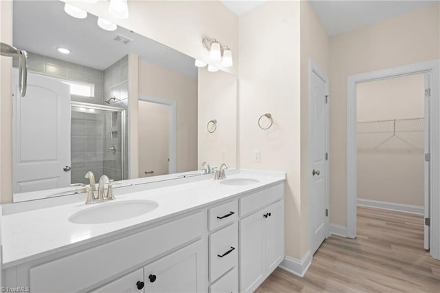 bathroom with vanity, wood-type flooring, and a shower with door