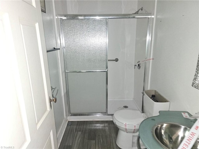 bathroom with toilet and an enclosed shower