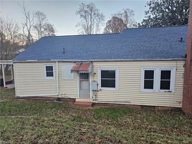 rear view of property featuring a lawn