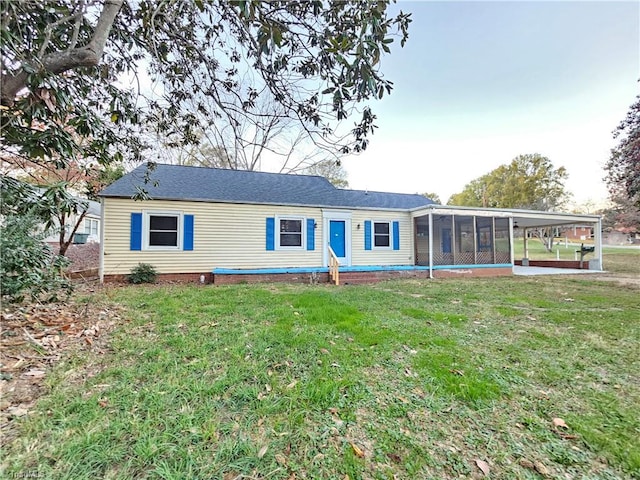 view of front of home with a front yard, a carport, and a sunroom