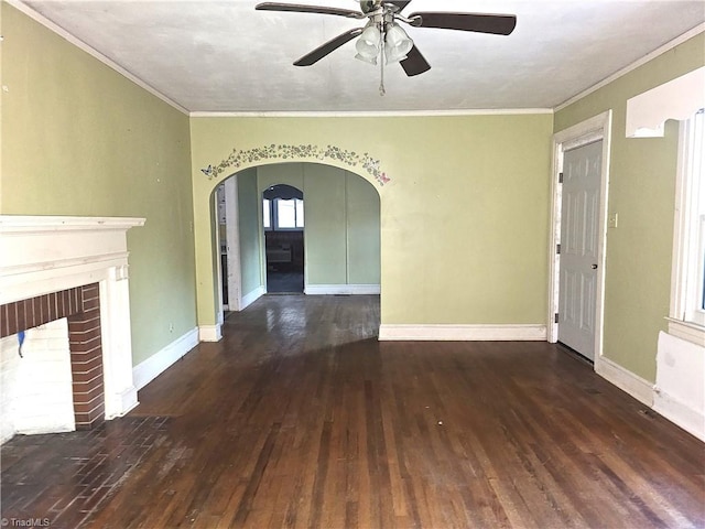 unfurnished living room with ceiling fan, dark hardwood / wood-style flooring, ornamental molding, and a fireplace