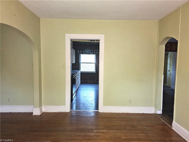 unfurnished room with dark hardwood / wood-style flooring