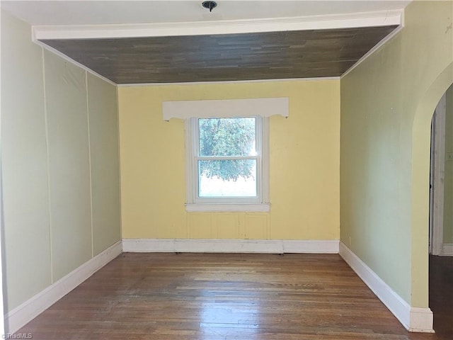 empty room with crown molding and dark wood-type flooring