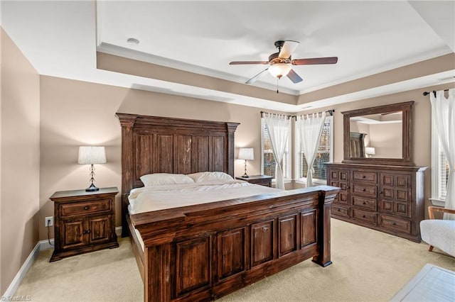 bedroom with ceiling fan, a raised ceiling, light colored carpet, and ornamental molding