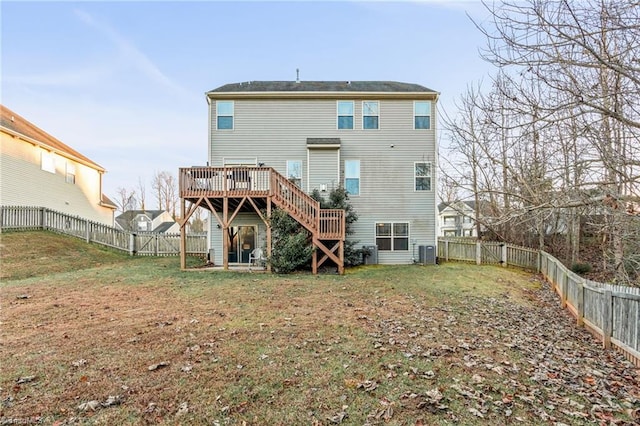 rear view of property featuring cooling unit, a deck, and a yard