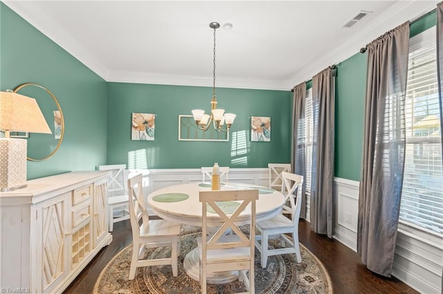 dining space featuring ornamental molding, dark hardwood / wood-style floors, and a notable chandelier