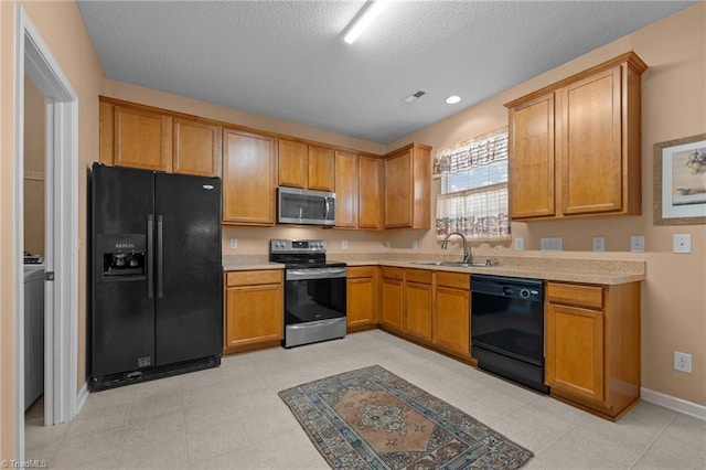 2503 Macdougall Dr, Burlington, NC 27217 - kitchen featuring black appliances, a textured ceiling, light countertops, and a sink