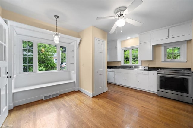 986 Avon Rd, Winston-Salem, NC 27104 - kitchen featuring stainless steel gas stove, white cabinetry, light wood-style floors, baseboards, and dark countertops