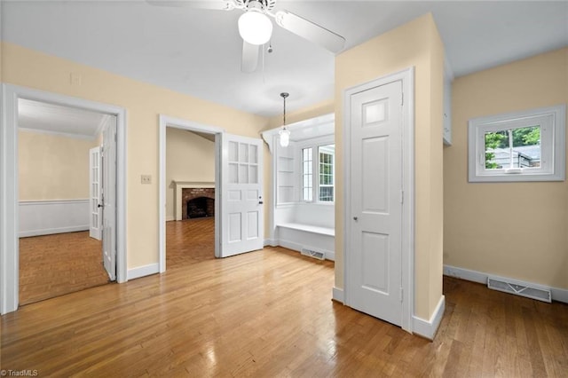 986 Avon Rd, Winston-Salem, NC 27104 - unfurnished bedroom featuring a fireplace, light wood-style floors, and multiple windows