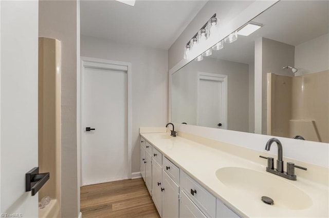 bathroom with wood-type flooring, walk in shower, and vanity