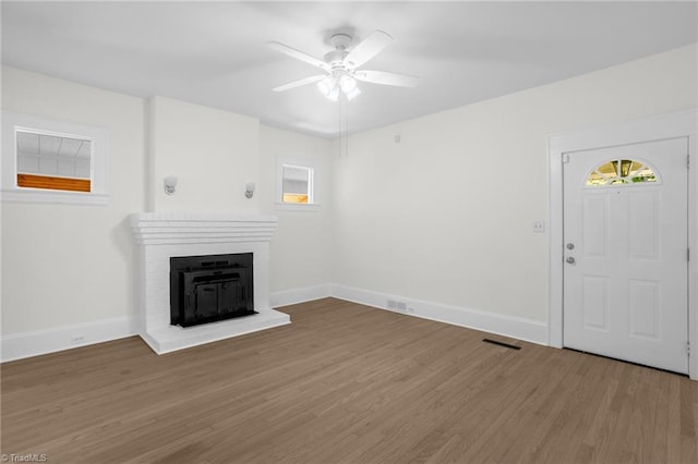 4221 Old Greensboro Rd, Winston-Salem, NC 27101 - unfurnished living room featuring ceiling fan, healthy amount of natural light, wood finished floors, and a fireplace
