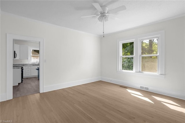 4221 Old Greensboro Rd, Winston-Salem, NC 27101 - unfurnished room featuring crown molding, light wood finished floors, healthy amount of natural light, ceiling fan, and baseboards