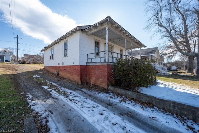 view of snow covered exterior with a porch