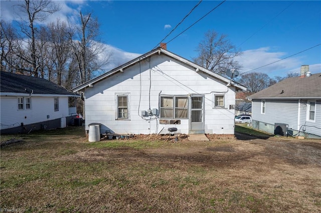 rear view of property with a lawn and central AC