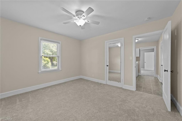 empty room featuring light colored carpet and ceiling fan