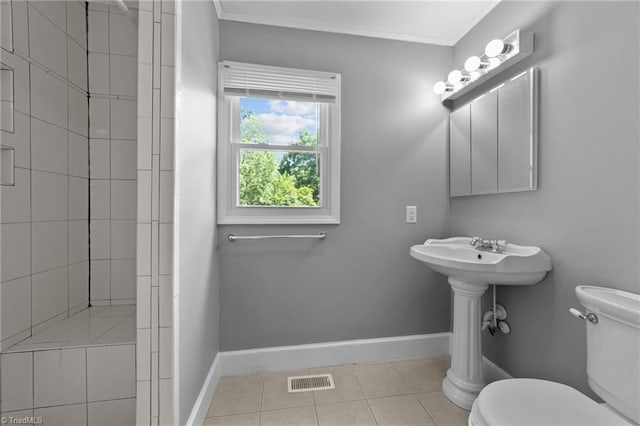 bathroom with toilet, tile floors, and crown molding