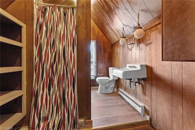 bathroom with hardwood / wood-style floors, toilet, wood walls, lofted ceiling, and a baseboard radiator