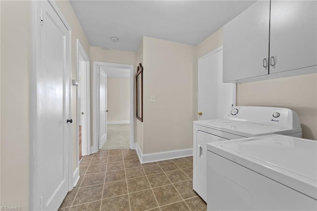 clothes washing area featuring cabinets, tile flooring, and washing machine and clothes dryer