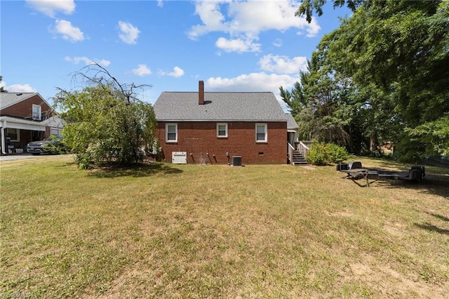 rear view of property featuring a lawn