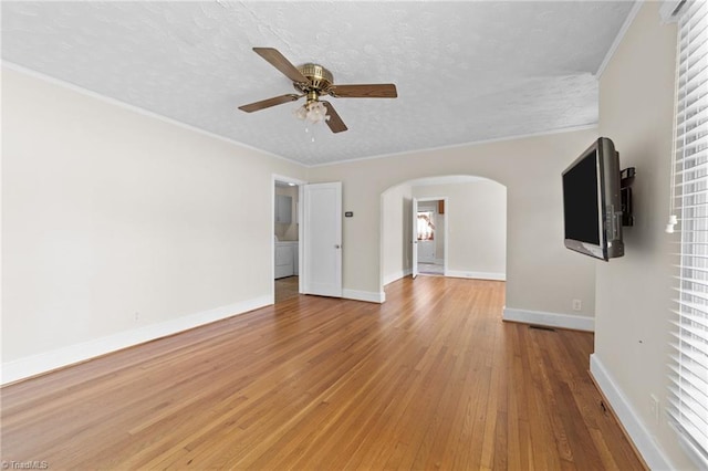 unfurnished living room featuring ceiling fan, light hardwood / wood-style flooring, a textured ceiling, and crown molding