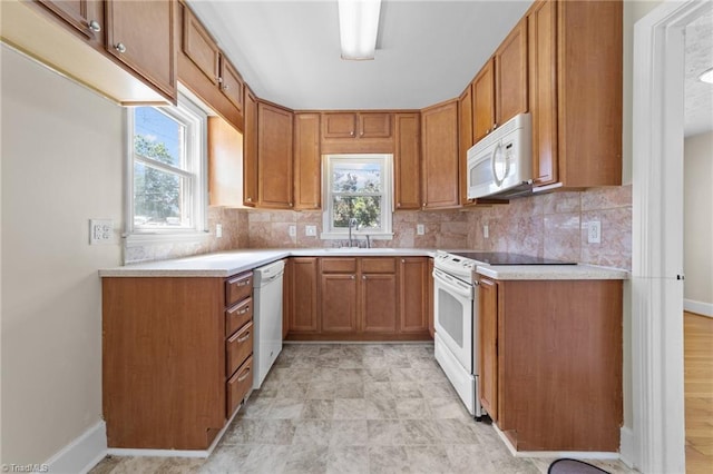 kitchen featuring backsplash, sink, white appliances, and light tile flooring