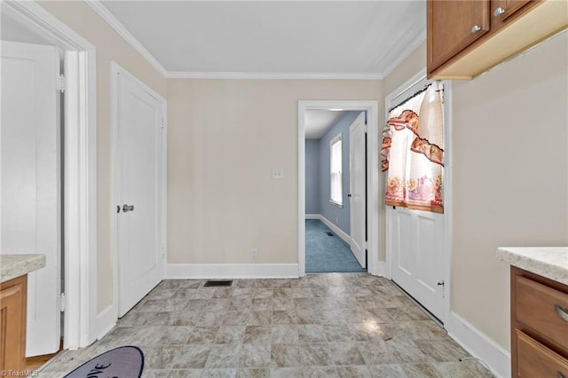 hallway featuring ornamental molding and light tile floors