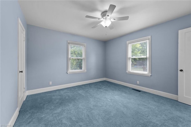 carpeted empty room featuring a wealth of natural light and ceiling fan