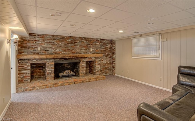 living room with carpet flooring, a fireplace, and a drop ceiling