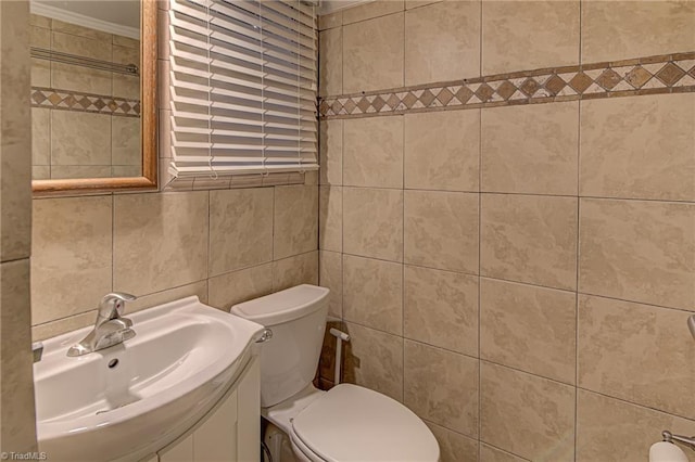 bathroom featuring crown molding, vanity, tile walls, and toilet